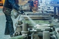 Woman worker sprays special molds for smelting metal parts in foundry workshop