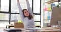 Woman worker stretches hands and arms before wrapping up task