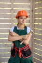 Woman worker with tools. Young girl in overalls and helmet posing on construction site Royalty Free Stock Photo