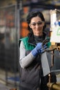 Woman worker wearing safety goggles control lathe machine to drill components. Metal lathe industrial manufacturing Royalty Free Stock Photo