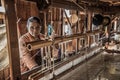 Woman worker weaves fabric in a weaving factory