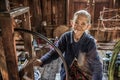 Woman worker weaves fabric in a weaving factory