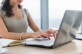 Woman working as copywriter at home. Close-up picture of female hands on pc keyboard in light office.