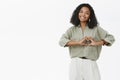 Woman working as volunteer trying maintain peace and love in worlds showing heart gesture over chest smiling friendly