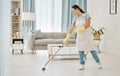 Woman working in a cleaning service mopping the living room floor of a modern home or apartment. Asian cleaner or Royalty Free Stock Photo