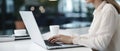 Woman working on computer in modern office, close up. Woman hands typing on keyboard of laptop, online shopping detail Royalty Free Stock Photo