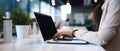 Woman working on computer in modern office, close up. Woman hands typing on keyboard of laptop, online shopping detail Royalty Free Stock Photo