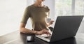 Woman working on computer and holding coffee cup in morning. Businesswoman using laptop at home or office. Royalty Free Stock Photo