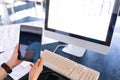 Woman working on computer and holding a digital tablet Royalty Free Stock Photo