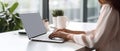 Woman working on computer in modern office, close up. Woman hands typing on keyboard of laptop, online shopping detail Royalty Free Stock Photo