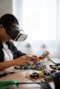A woman is working on a computer with a VR headset on. She is fixing a computer part Royalty Free Stock Photo