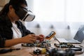 A woman is working on a computer with a VR headset on. She is fixing a computer part Royalty Free Stock Photo
