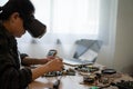 A woman is working on a computer with a VR headset on. She is fixing a computer part Royalty Free Stock Photo