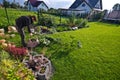 Woman working in a garden, cutting excess twigs of plants