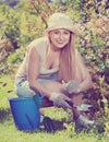 Woman working in garden using horticultural instruments on summer day Royalty Free Stock Photo