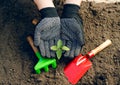 Woman in working gloves working in ground with gardening tools, plants a plant Royalty Free Stock Photo