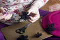 Woman working on a headdress. Sewing flower of cloth.