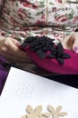 Woman working on a headdress. Sewing flower of cloth.