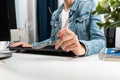 Woman working at her home office, hipster girl freelance writing on computer and holding glasses in her hand. Business concept Royalty Free Stock Photo