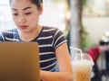 Woman working on her laptop in the cafe under tunsten light. Royalty Free Stock Photo