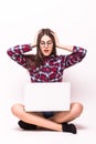 Woman working on her laptop, sitting on the floor over sparse Royalty Free Stock Photo