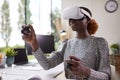 Woman Working From Home Office With Controllers Wearing VR Headset Interacting With AR Technology Royalty Free Stock Photo