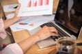 Woman working at home office desk using laptop business financial document chart and graph on wooden table with coffee cup. Woman Royalty Free Stock Photo