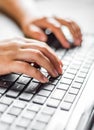 Woman working at home office hand on keyboard close up on wooden table Royalty Free Stock Photo