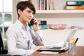 Woman Working From Home Using Laptop On Phone Royalty Free Stock Photo