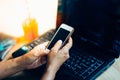 Woman working from home using smart phone and notebook computer, woman hands using smart phone in interior Royalty Free Stock Photo