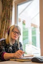 Woman working from home watching webinar on her laptop,wearing headphones Royalty Free Stock Photo