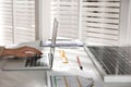 Woman working on house project with solar panels at table in office Royalty Free Stock Photo