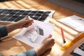Woman working on house project with solar panels at table in office Royalty Free Stock Photo