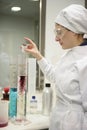 Woman working laboratory, glass cylinder vase