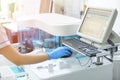 Woman working in a laboratory on a modern machine for blood testing.