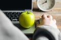 A woman working on laptop, apple closeup, snack concept. Royalty Free Stock Photo