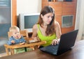 Woman working with laptop and baby