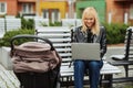 Woman working with laptop on a bench while her little child sleeping Royalty Free Stock Photo