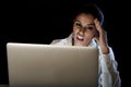 Woman working on laptop computer late at night looking stressed bored and tired Royalty Free Stock Photo