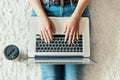 Woman working on a laptop. Female using a laptop sitting on floor, searching web, browsing information, Royalty Free Stock Photo