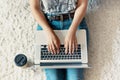 Woman working on a laptop. Female using a laptop sitting on floor, searching web, browsing information, having workplace at home. Royalty Free Stock Photo