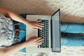 Woman working on a laptop. Female using a laptop sitting on floor, searching web, browsing information Royalty Free Stock Photo