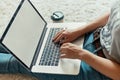 Woman working on a laptop. Female using a laptop sitting on floor, searching web, browsing information, having workplace at home. Royalty Free Stock Photo