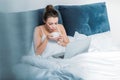 Woman working on laptop and having morning coffee in bed Royalty Free Stock Photo