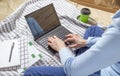 Woman working for laptop from home on bed. Girl using portable computer for writing on keyboard at her office with cup of coffee Royalty Free Stock Photo