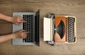 Woman working with laptop near old typewriter at wooden table, top view. Concept of technology progress Royalty Free Stock Photo