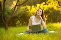 Woman working on laptop stiiting on the green grass Royalty Free Stock Photo