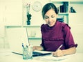 Woman working with laptop and taking notes Royalty Free Stock Photo