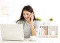 Woman working on laptop and talking on the phone Royalty Free Stock Photo