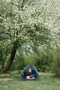 Woman working on laptop in tent in nature. Young freelancer sitting in camp Royalty Free Stock Photo